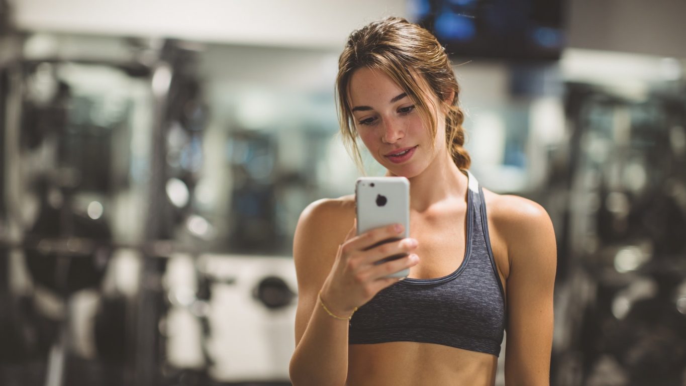 Девушка фотографирут себя в спортзале